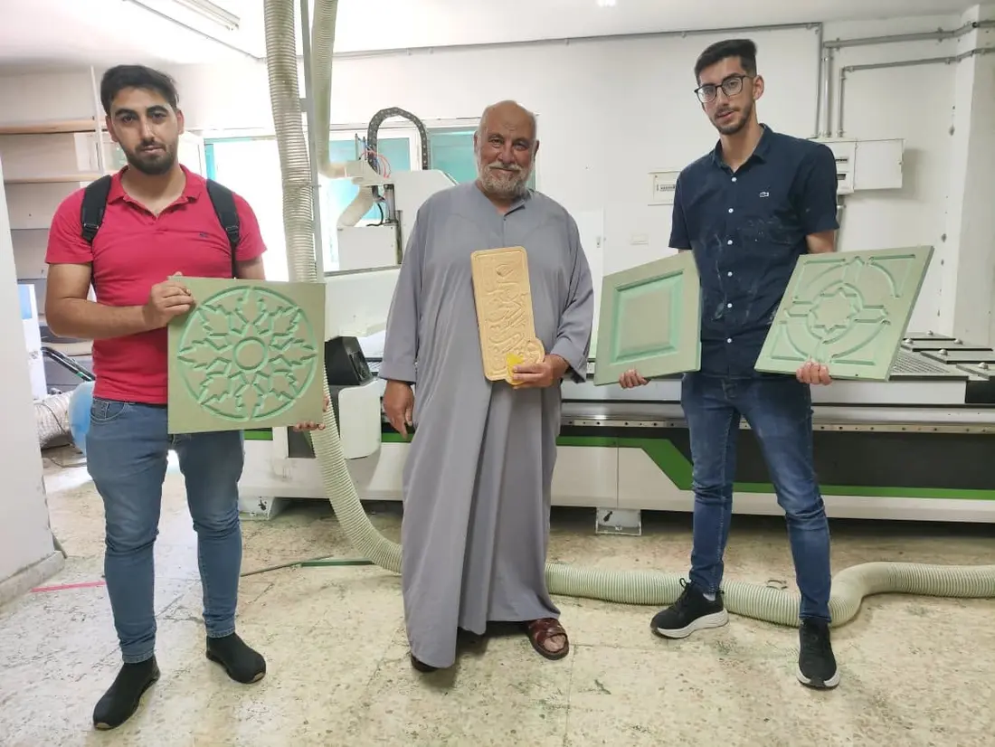 طلاب مع أعمالهم أمام الماكينة